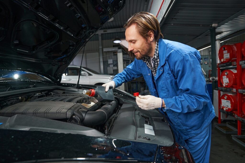 Car mechanic performing car maintenance at service station