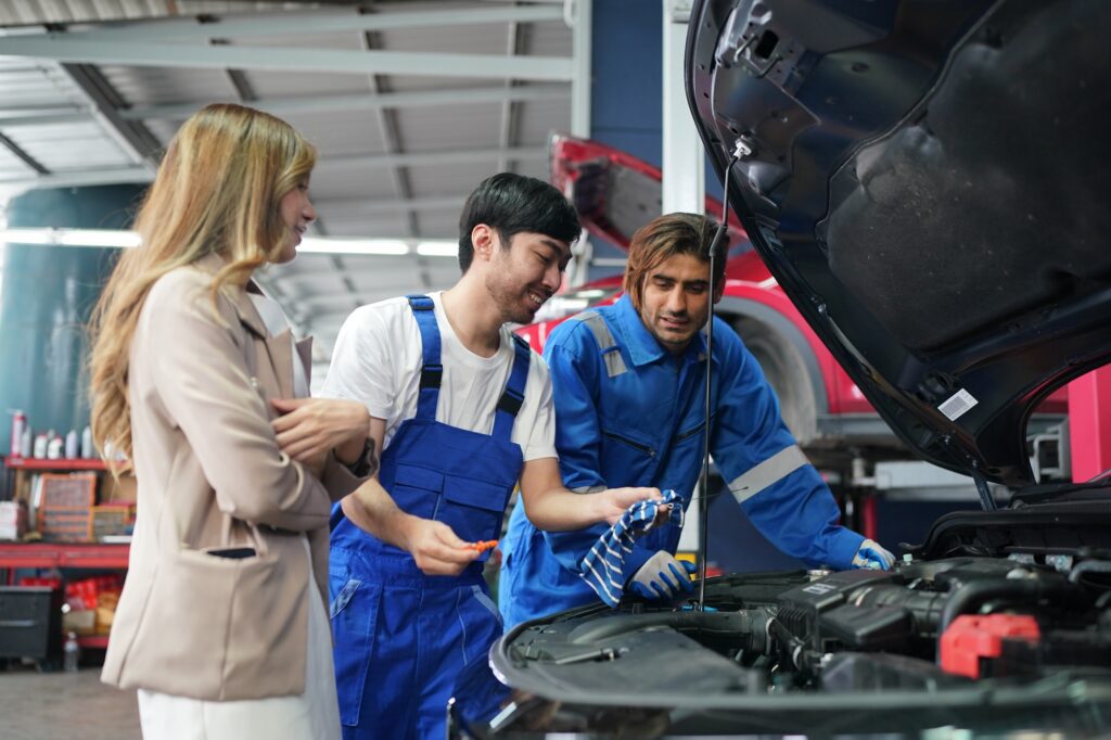 Mechanic in blue overalls checking serviceability of car engine