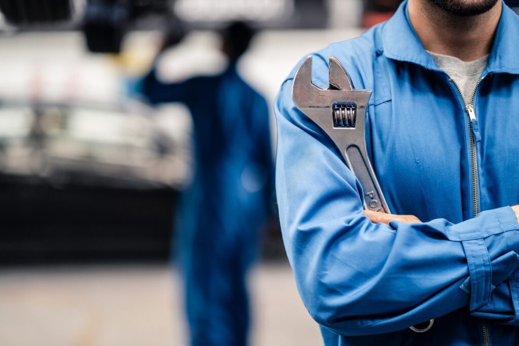 No face shot of car mechanic male worker holding equipment tool standing in maintenance