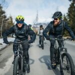 Group of mountain bikers riding on road outdoors in winter