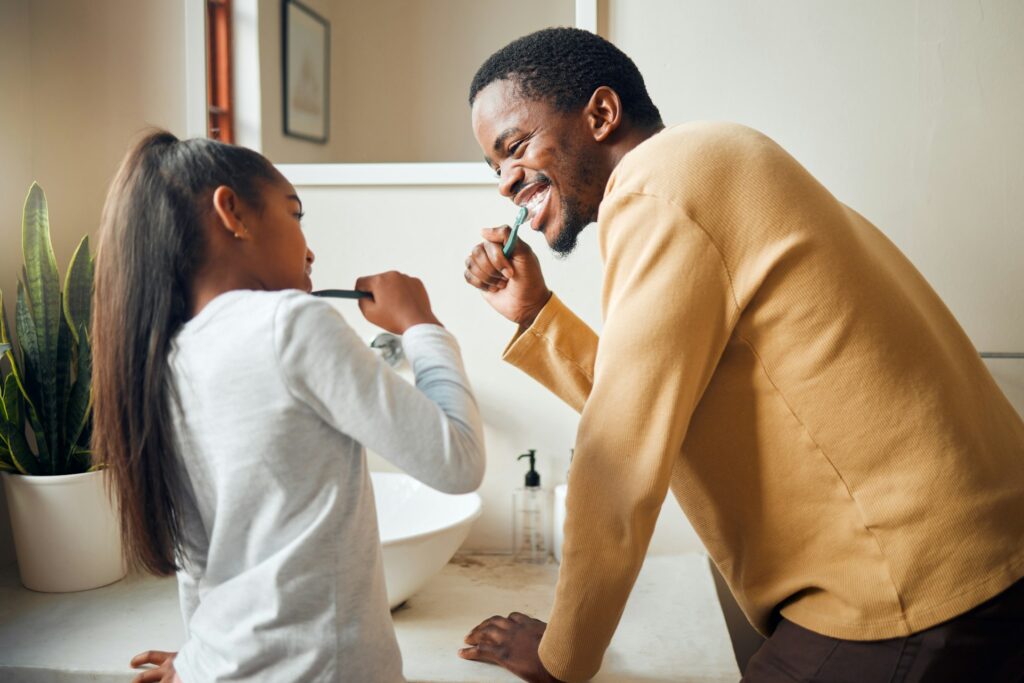 Oral care, brushing teeth and father with daughter in bathroom for hygiene, grooming and bonding. D