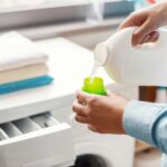A housewife carefully doses the detergent to put in the washing machine