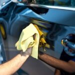 Worker washing car with sponge on a car wash, Manual car wash with white soap, Car wash self service