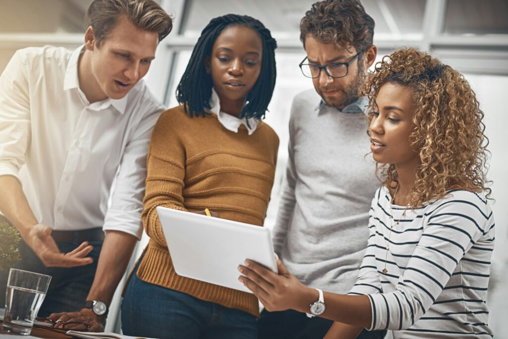 Shot of a group of businesspeople looking at something on a digital tablet