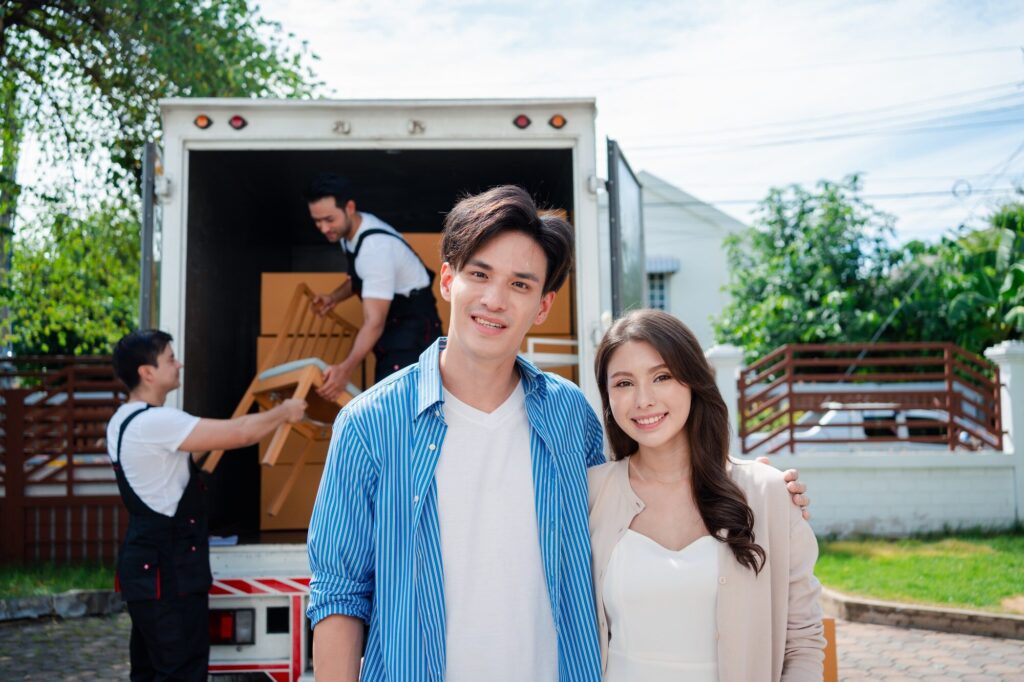 Asian Couple check while unloading boxes and furniture from a pickup truck
