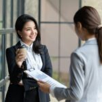 Confident focused businesswoman, teacher or mentor coach speaking to business people at negotiations