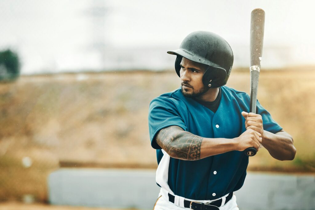 Baseball player, training and bat for fitness workout on outdoor sports field. Serious athlete batt