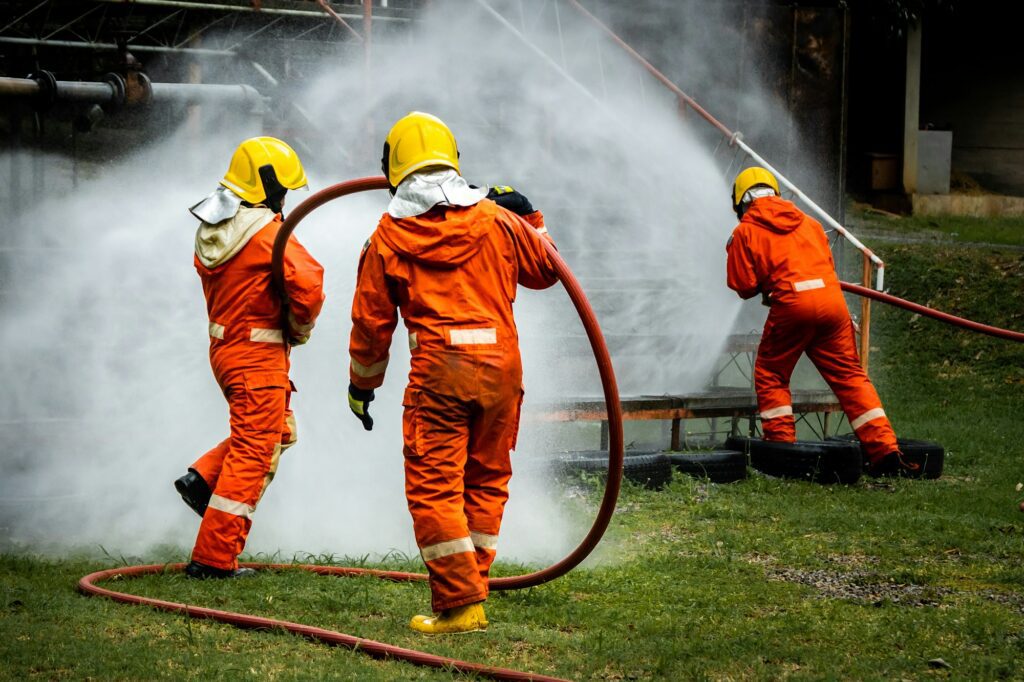 Firefighter Concept. Fireman using water and extinguisher to fighting with fire flame.