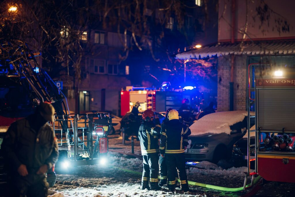 Firemen at work near their truck on the street.