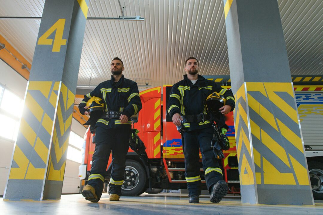 Group of firefighters at the emergency vehicle in the fire station