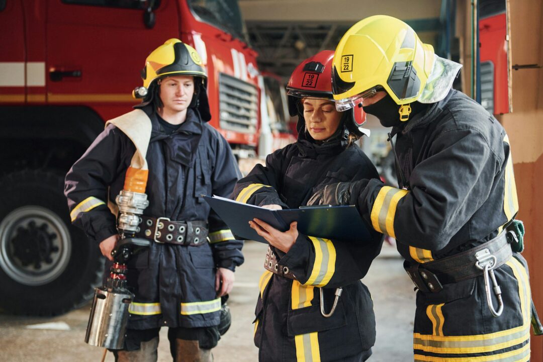 With notepad. Group of firefighters in protective uniform that is on station