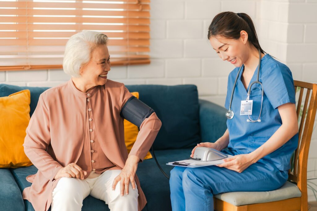 Health insurance service, Young Asian caregiver nurse examine senior man or woman patient at home