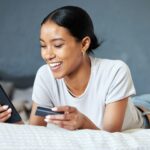 Payments, banking and online shopping with ecommerce by a woman with a credit card and phone on her