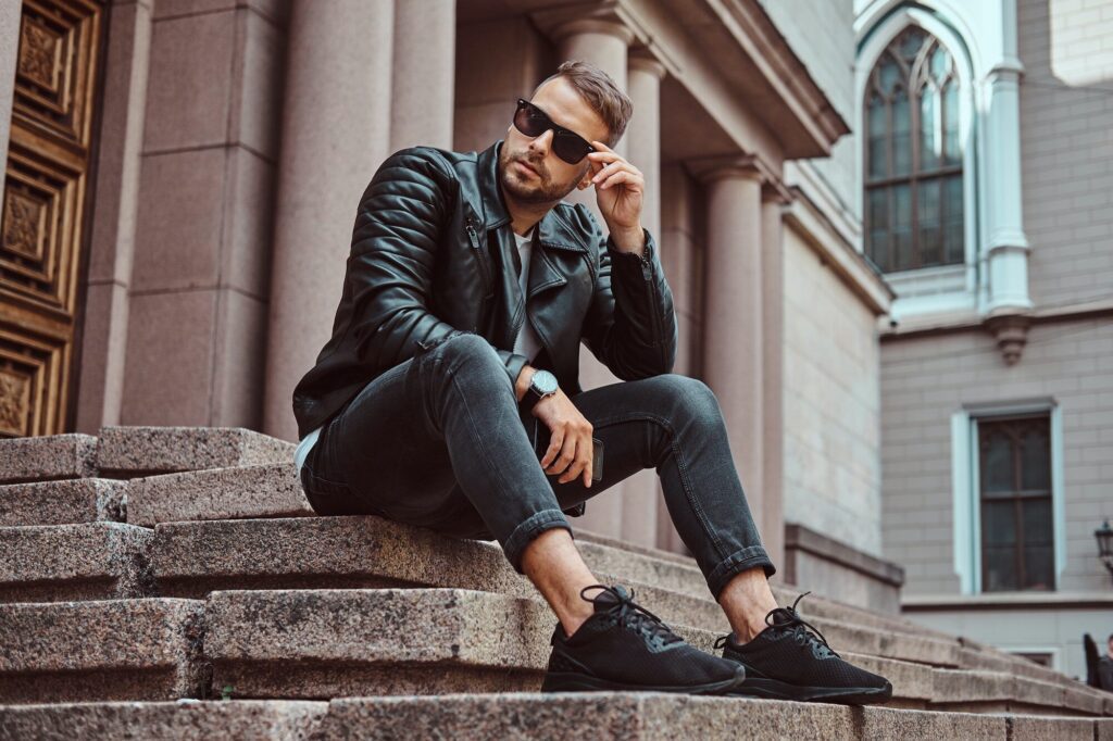 Fashionable guy dressed in a black jacket and jeans