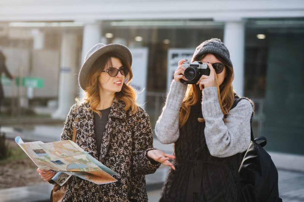 Stylish city portrait of two fashionable girls walking in Europe modern city centre. Fashionable fri