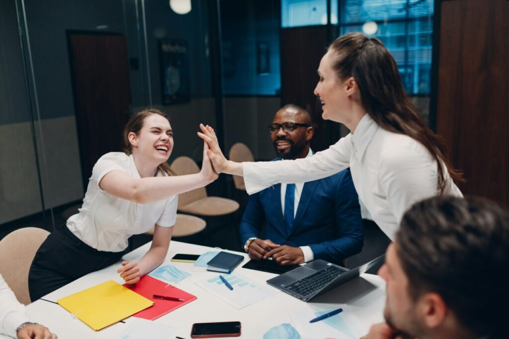 Businessman and businesswoman team at office meeting. Business people group conference high five