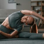 Stretching the spine. Young woman in yoga clothes doing fitness indoors